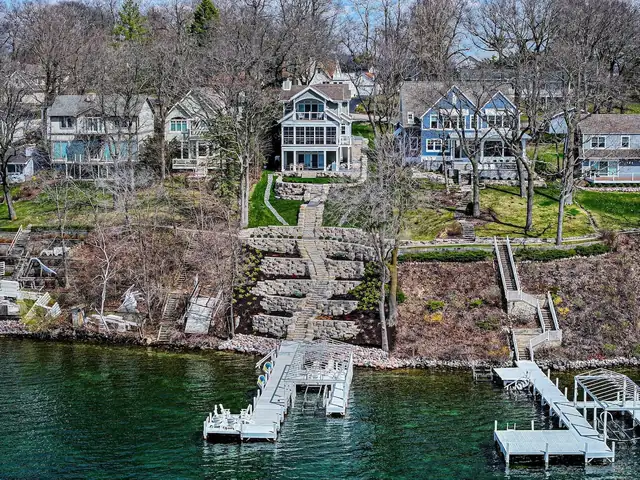 Aerial view of a remodeled lakefront home in Williams Bay with stone steps down to the pier